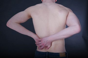 Closeup view of a young man with lower back pain.