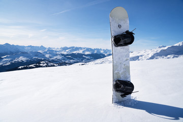 Snowboard Standing In Snow With Winter Mountains In Background