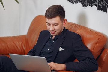 Handsome man in a black suit. Businessman working in a office