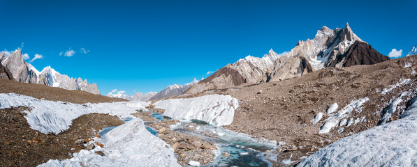 Panoramic view of turquoise water on Baltoro Galcier with Marble Peak in background, nearby Concordia Camp in the morning, Pakistan