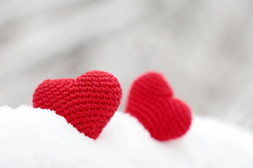Obraz premium Love hearts, Valentine's card, two red knitted symbols of passion in the snow. Background for romantic event, celebration or winter weather