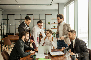 thoughtful caucasian business people in tux work in office, using laptop, look at screen of laptop and develop new business startup