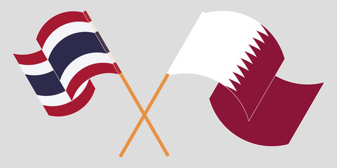 Crossed and waving flags of Thailand and Qatar