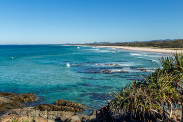 Fototapeta na wymiar Bright blue ocean with small white waves breaking on a beach in Queensland Australia