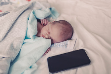 newborn baby sleeping in hospital with mobile