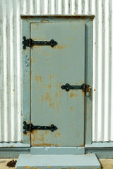 A Gray Door on a White Corrugated Metal Building