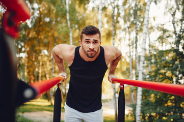 Obraz premium Man training. Guy in a sports shorts. Male in a summer park