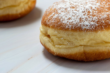 Two donuts in close-up, isolated on white marble backdrop. Filled with jam.