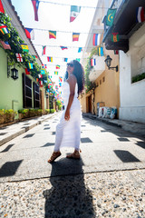 Beautiful local Colombian woman in white dress in the walled city of Cartagena, Colombia