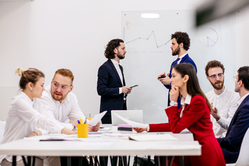 friendly business team in boardroom, in modern office gathered to discuss, have conversation about business strategies, ideas and projects. brainstorm of diverse young caucasian people in formal wear
