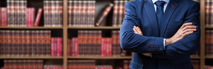Midsection Of Lawyer Standing Against Bookshelf