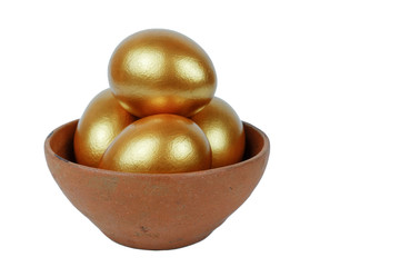 Golden Easter eggs in a clay bowl