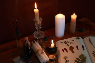 magic ritual of the alchemist with candles, runes and symbols