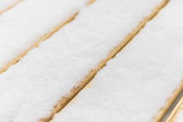 Snow covered wooden bench