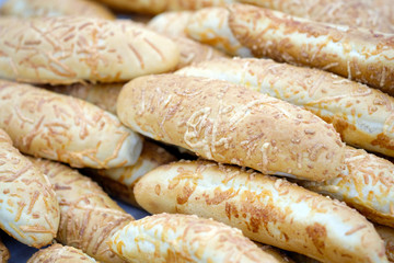 Muffins sprinkled and baked with cheese on top. Hot dog buns. The bread department in the store.