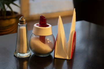 Castor, a sugar bowl, napkins on a tray made of stainless steel.