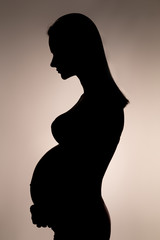 silhouette of a pregnant woman with her hair