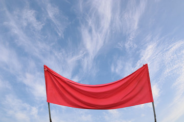 A piece of red cloth against the blue sky. Flight ban concept. Digital composition.
