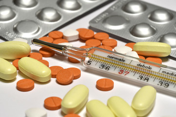 medicine pills with fever thermometer. concept image