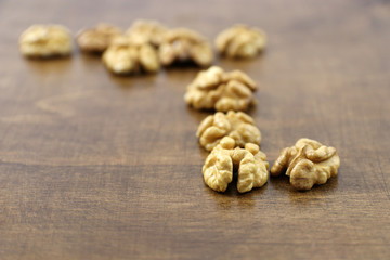 Walnuts kernels on dark wooden table.
