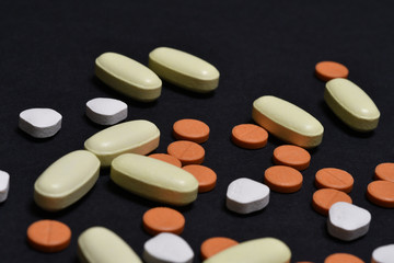 various medicine pills on black background