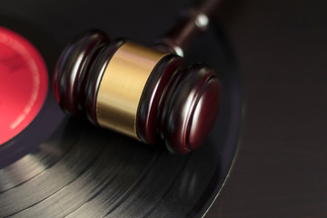 Judge's gavel and vinyl record. Concept of entertainment lawsuit, music piracy and copyright...