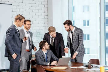 business coworking in office, young caucasian boss in stylish elegant tuxedo sit with colleagues or co-workers in modern executive office, discuss business strategies