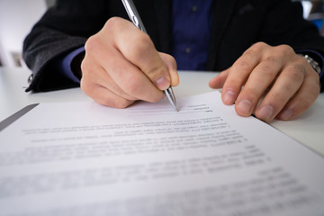 Close-up Of Businessman Holding Pen