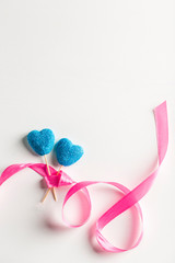Marmalade in sugar blue in the form of hearts on sticks with ribbon on white background closeup with copyspace. Valentine's day holiday concept.