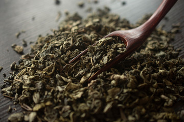 green tea and a wooden spatula sprinkles tea on wooden background. food photography