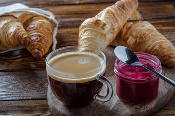 croissant and cup of coffee on wooden table