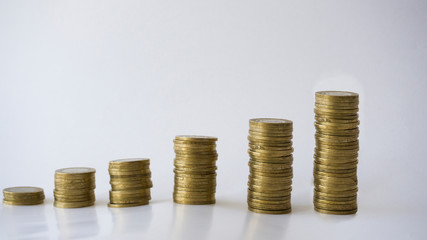 Saving and growth concept with metal coins isolated on white background. Saving money for education, summer holiday vacation, new house, new entrepreneurship or basic needs loan. Step by step.