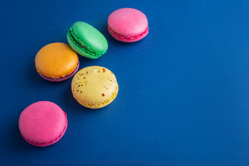 multicolored macaroons on a blue background top view