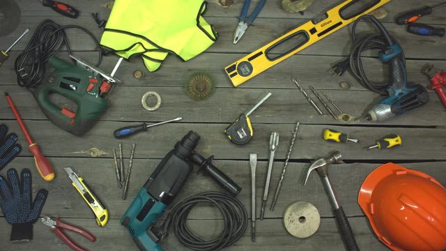 The friendship of two small yellow screwdrivers. Stop motion animation. Top view.  On the table are tools for various types of construction and repair work on wood, metal, concrete, plastic and other.