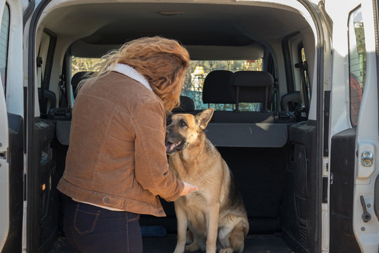 Mujer prepar&aacute;ndose con su perro pastor alem&aacute;n para viajar  