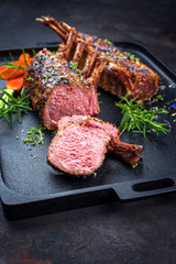 Gegrilltes Lamm Nacken Karree  mit Karotten und Kräuter angeboten als closeup auf einem Modern...