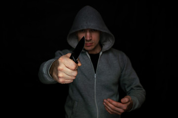 A man threatening with a knife in his hand on a black background