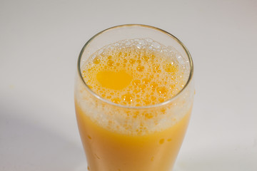 Freshly squeezed orange juice with fruits on a white kitchen table. Glass of fresh orange juice isolated on white background.
