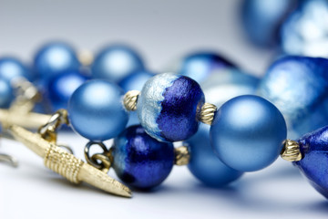 Macro abstract view of a vibrant blue and gold vintage costume jewelry necklace on a white background with copy space