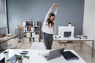 Businesswoman Stretching At Desk