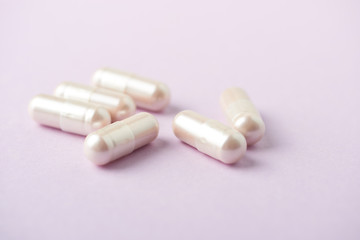 Carnitine capsules. Concept for a healthy dietary supplementation. Bright paper background. Soft focus. Close up.