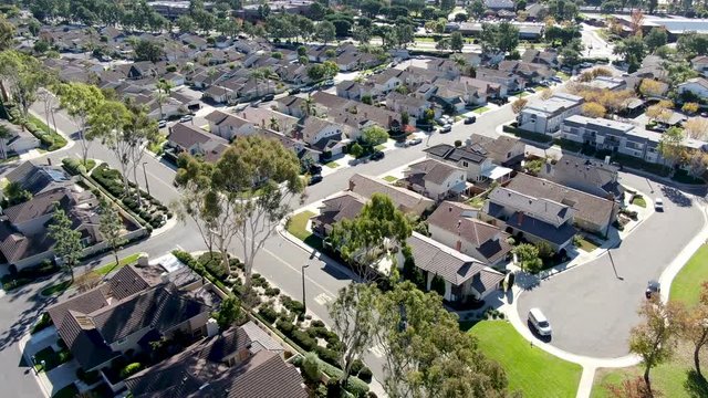 Aerial view of residential suburban packed homes neighborhood during blue sky day in Irvine, Orange County, USA