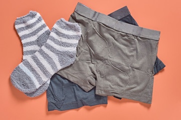 Striped soft and warm socks and new dark underpants on orange background. Close-up