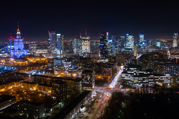 Naklejka na ściany i meble Warsaw-Poland 04. December. 2019. Aerial view of luminous high-rise buildings of the business center with lighted windows located in Warsaw against the evening sky. 