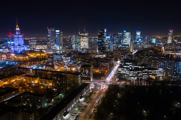 Drone fired at a city at night with skyscrapers in the business district of Warsaw. Poland. 03. December. 2019. Aerial view of bright lights and nightlife in the business center of Warsaw.
