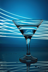 a glass of martini on a blue background