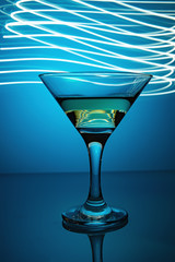 a glass of martini on a blue background