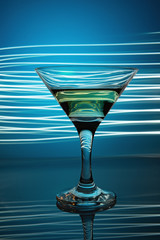 a glass of martini on a blue background