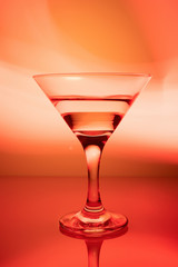 a glass of martini on a red background