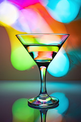 a glass of martini on a multicolor background